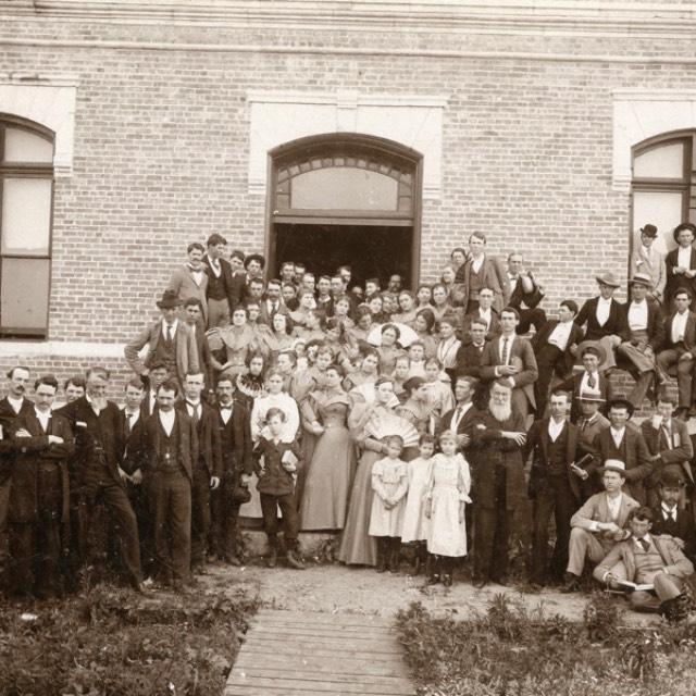 1895年，一群学生和教师聚集在阿德兰基督教大学的一座建筑前拍照
